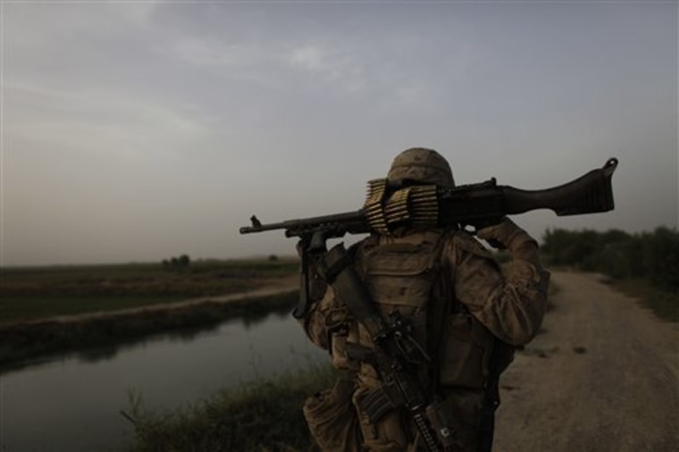 A U.S. Marine nearing an end to his tour of duty carries a machine gun in Helmand province, southern Afghanistan, on Sept. 24, 2011.